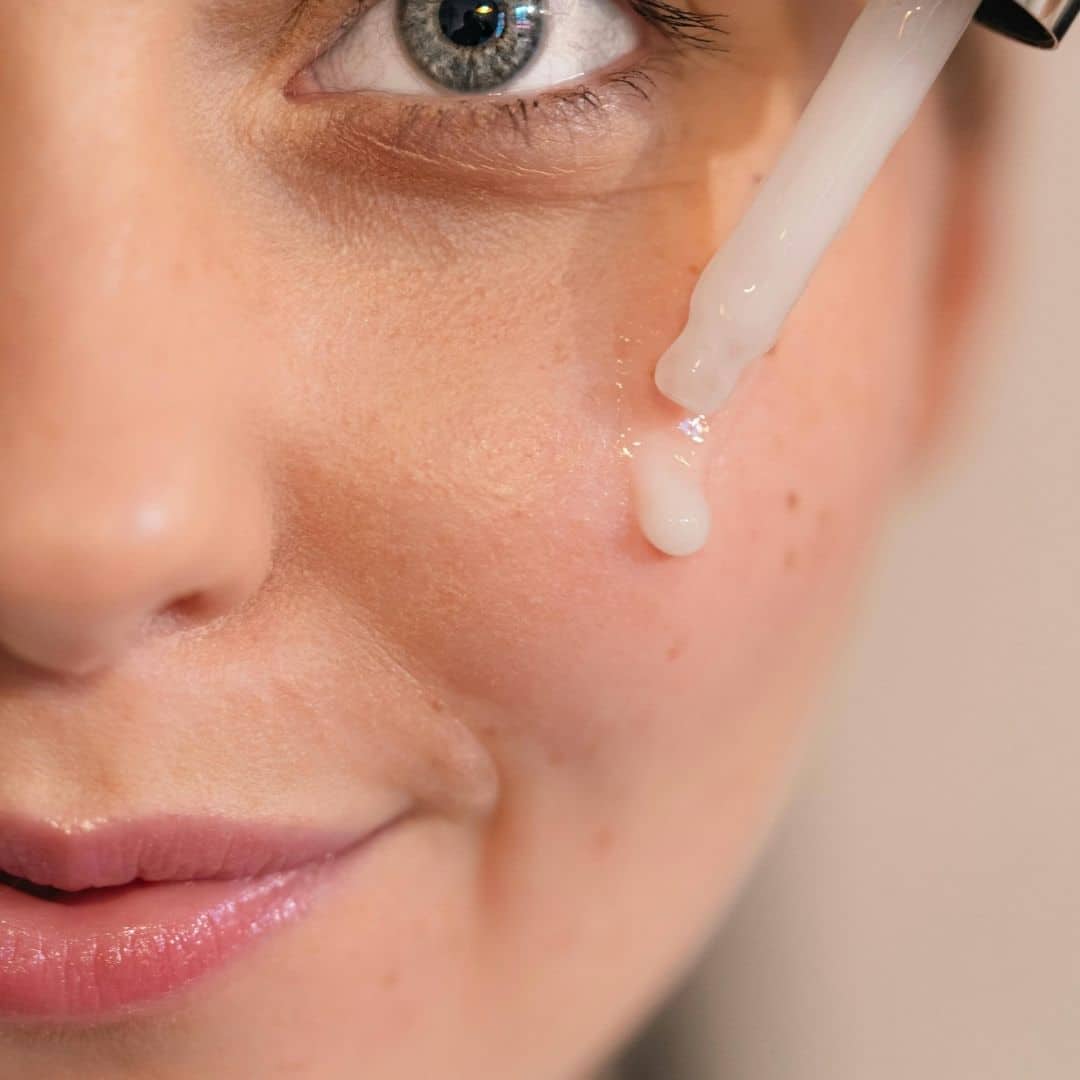 a woman applying serum